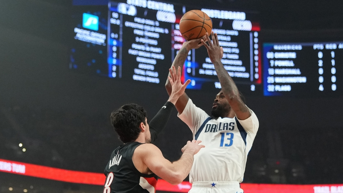 Naji Marshall #13 of the Dallas Mavericks takes a jumper over Deni Avdija #8 of the Portland Trail Blazers during an NBA game at the Moda Center.