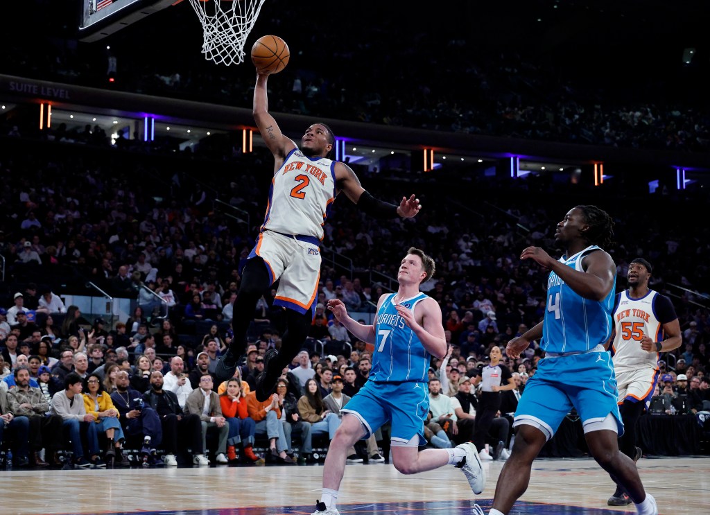 New York Knicks guard Miles McBride (2) dunks the ball over Charlotte Hornets guard Kon Knueppel (7).