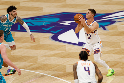 Phoenix Suns guard Collin Gillespie (12) prepares to shoot a 3-point basket during the first half of an NBA basketball game against the Charlotte Hornets in Charlotte, N.C., Thursday, April 2, 2026. (AP Photo/Nell Redmond)