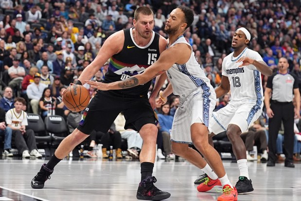 Denver Nuggets center Nikola Jokić, left, drives to the rim as Memphis Grizzlies forward Kyle Anderson defends in the second half of an NBA basketball game Wednesday, Feb. 11, 2026, in Denver. (AP Photo/David Zalubowski)