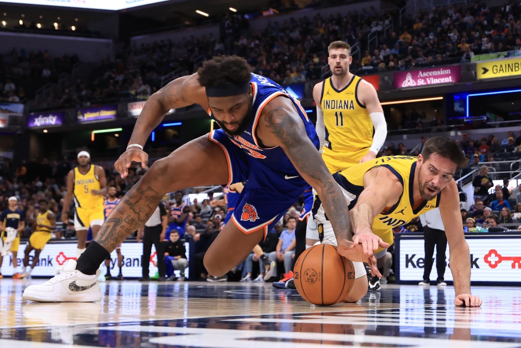 Mitchell Robinson and T.J. McConnell battle for the ball.