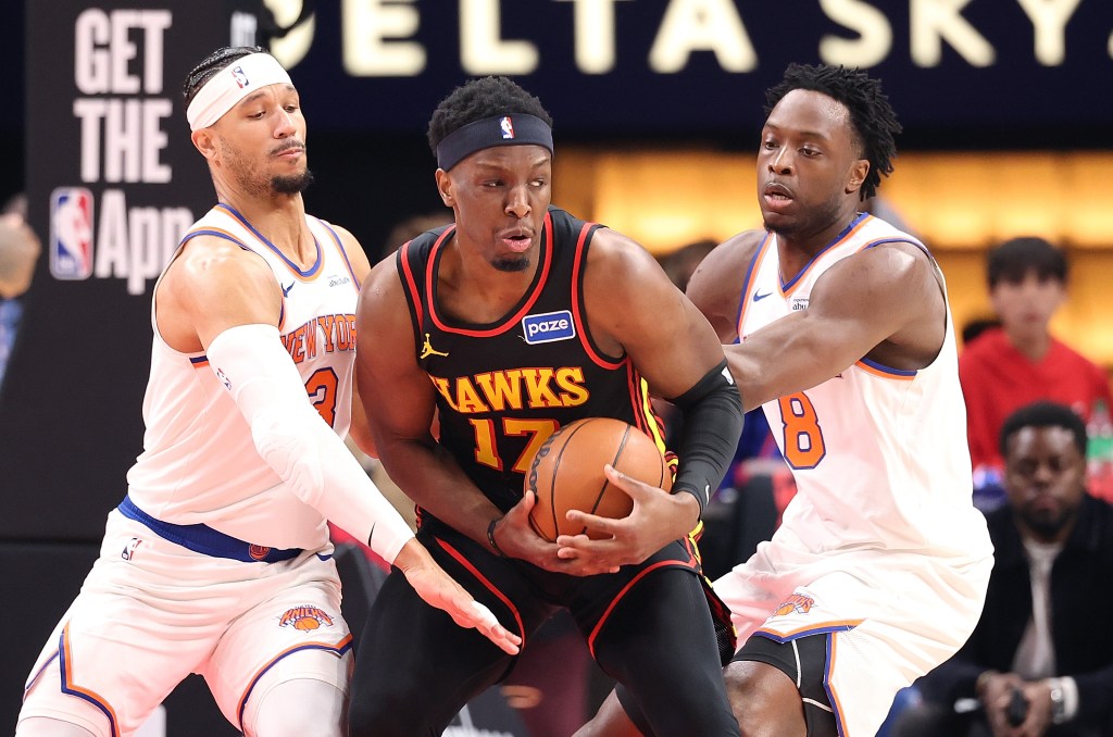 Onyeka Okongwu of the Atlanta Hawks drives past Josh Hart and Og Anunoby of the New York Knicks.