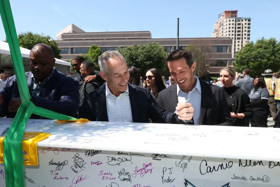 Hornets Sports & Entertainment Co‑Chairmen Rick Schnall and Gabe Plotkin signing final structural beam of the performance center
