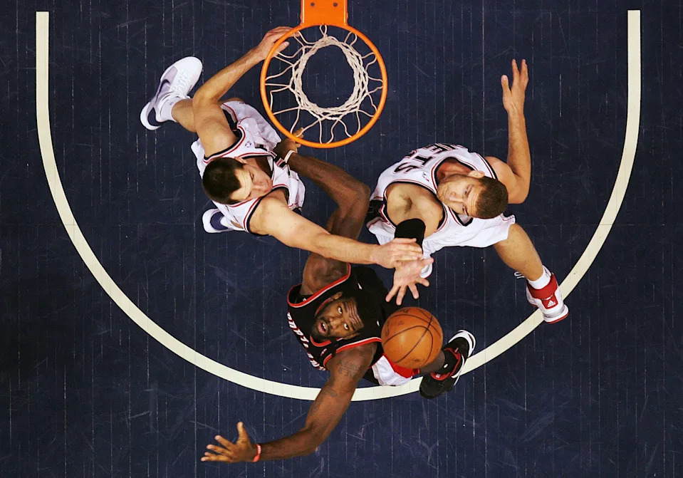 EAST RUTHERFORD, NJ - JANUARY 15: Greg Oden #52 of the Portland Trail Blazers battles Ryan Anderson #20 and Brook Lopez #11 of the New Jersey Nets during their game at the Izod Center January 15, 2009 in East Rutherford, New Jersey. (Photo by Al Bello/Getty Images)