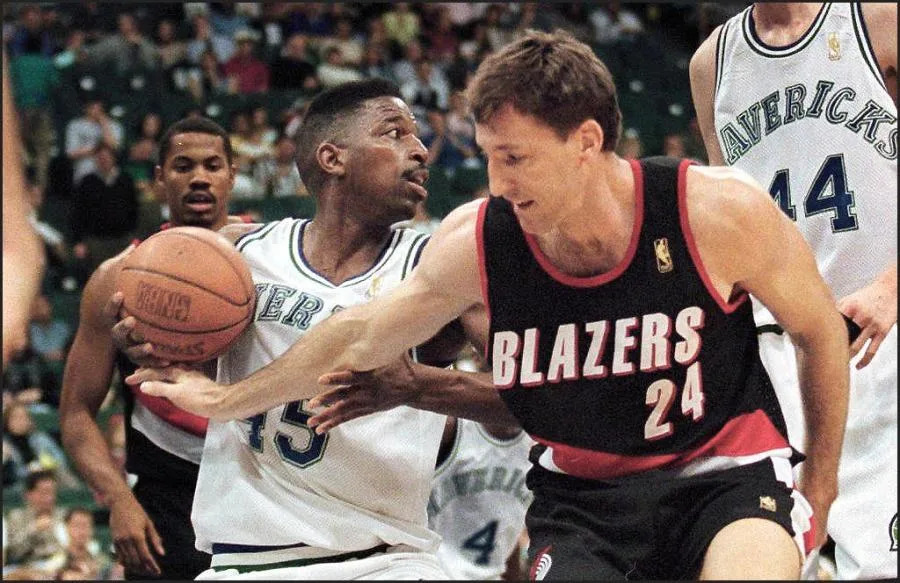 Dallas Mavericks’ A.C. Greene (L) grabs a rebound away from Chris Dudley of the Portland Trail Blazers (R) during first half action at Reunion Arena in Dallas, Texas, 08 April. (Photo by PAUL BUCK / AFP via Getty Images)