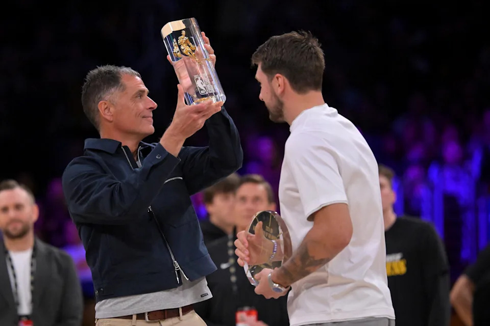 Apr 21, 2026; Los Angeles, California, USA; Los Angeles Lakers general manager Rob Pelinka shows off the NBA scoring champion trophy, along with the player of the month award give to guard Luka Doncic (77) prior to game two of the first round of the 2026 NBA Playoffs against the Houston Rockets at Crypto.com Arena. Mandatory Credit: Jayne Kamin-Oncea-Imagn Images