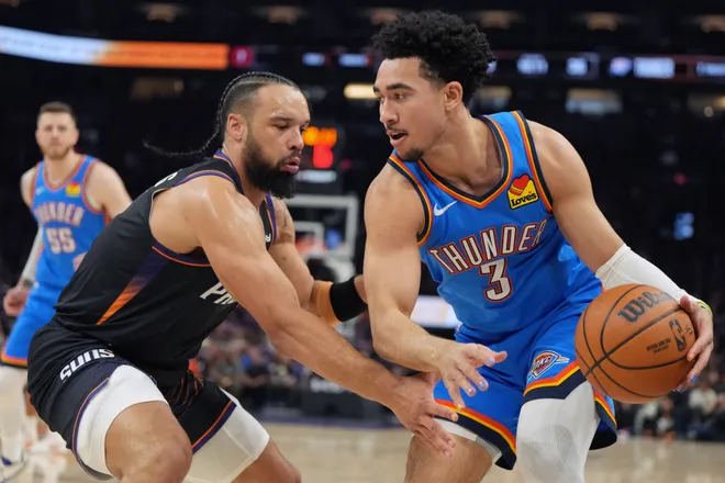 Apr 25, 2026; Phoenix, Arizona, USA; Oklahoma City Thunder guard Jared McCain (3) shields the ball from Phoenix Suns forward Dillon Brooks (3) in the first half during game three of the first round of the 2026 NBA Playoffs at Mortgage Matchup Center. Mandatory Credit: Rick Scuteri-Imagn Images