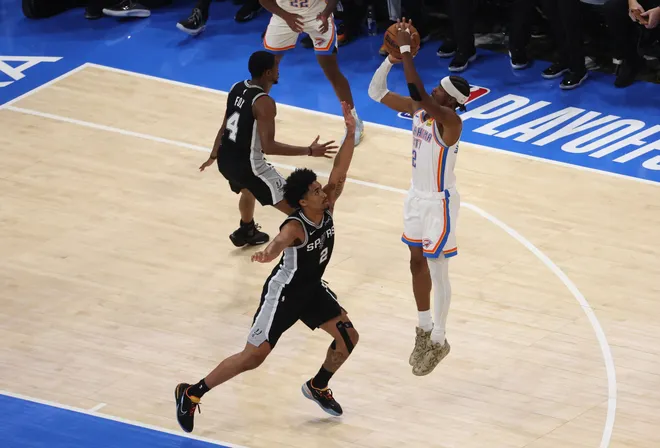 May 26, 2026; Oklahoma City, Oklahoma, USA; Oklahoma City Thunder guard Shai Gilgeous-Alexander (2) shoots against San Antonio Spurs guard Dylan Harper (2) during the third quarter in game five of the western conference finals for the 2026 NBA playoffs at Paycom Center. Mandatory Credit: Brett Rojo-Imagn Images