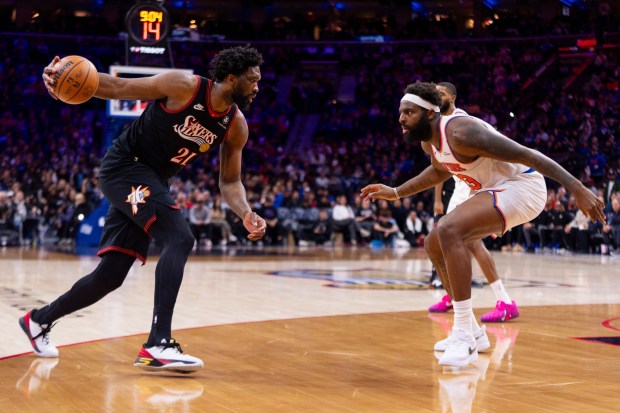 Philadelphia 76ers' Joel Embiid, left, in action against New York Knicks' Mitchell Robinson, right, during an NBA basketball game, Saturday, Jan. 24, 2026, in Philadelphia. (AP Photo/Chris Szagola)
