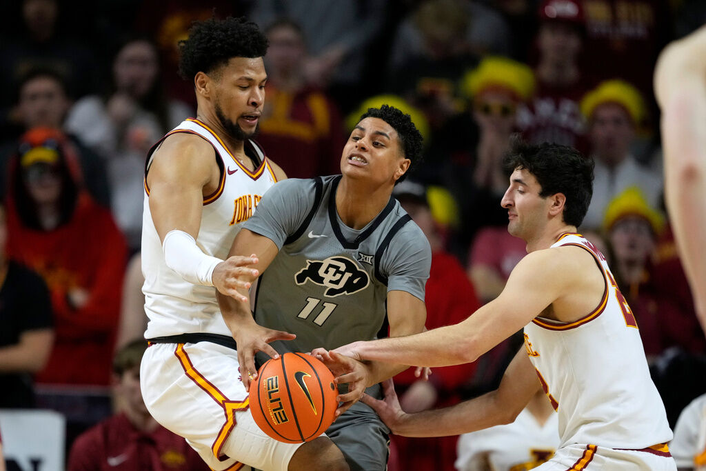 Colorado guard Jalin Holland (11) drives between Iowa State forward Joshua Jefferson, left, and forward Milan Momcilovic during the second half of an NCAA college basketball game, Thursday, Jan. 29, 2026, in Ames, Iowa. (AP Photo/Charlie Neibergall)