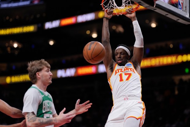 Atlanta Hawks forward Onyeka Okongwu, right, dunks against the Boston Celtics in the first half of an NBA game, Monday, March 30, 2026, in Atlanta. (AP Photo/Mike Stewart)