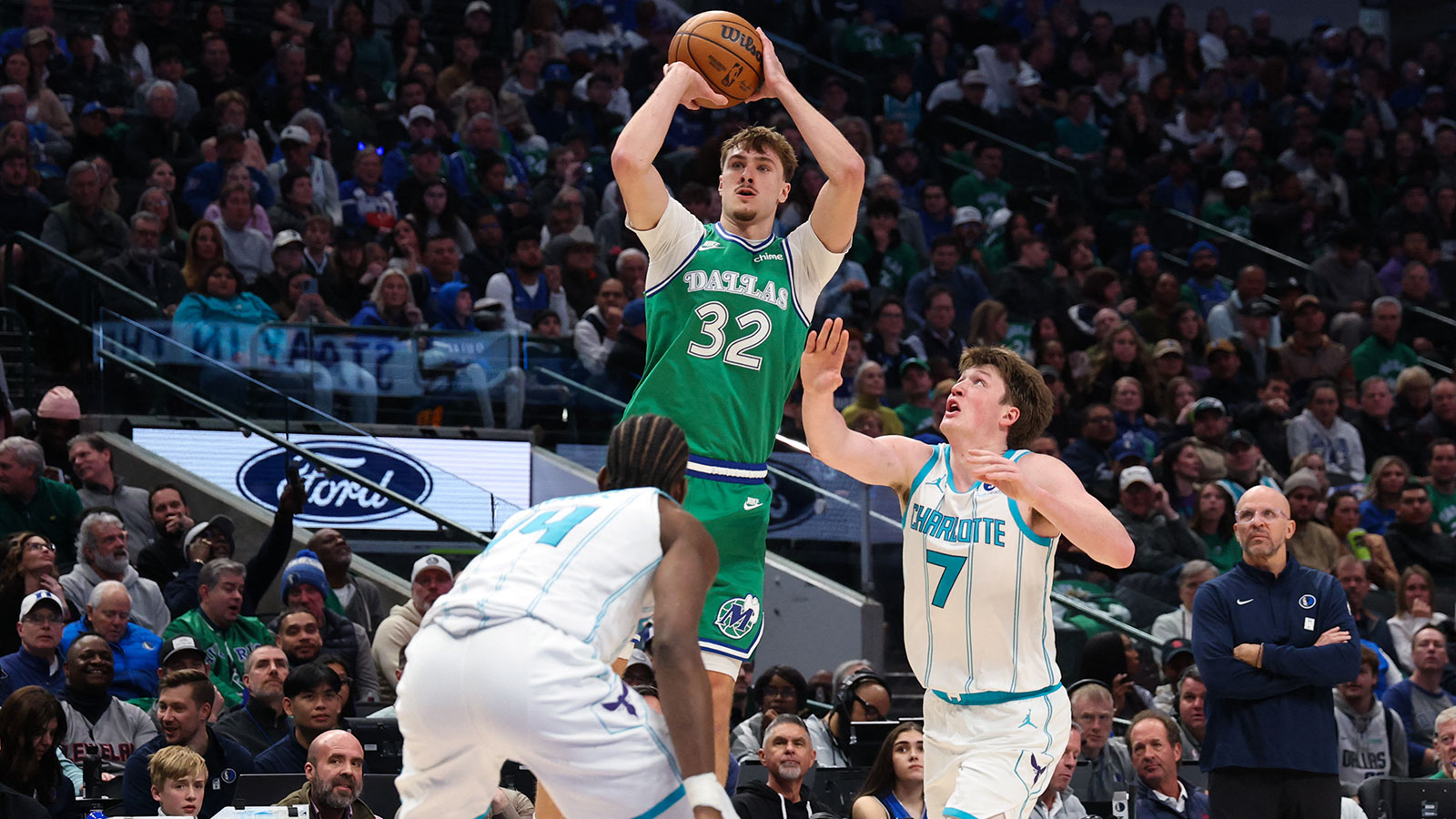 Dallas Mavericks forward Cooper Flagg (32) shoots over Charlotte Hornets forward Moussa Diabate (14) and Charlotte Hornets guard Kon Knueppel (7) during the second half at American Airlines Center.