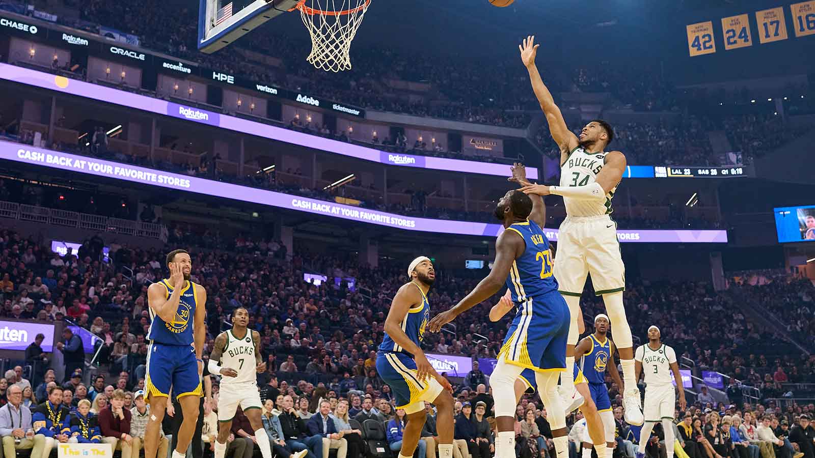 Milwaukee Bucks forward Giannis Antetokounmpo (34) shoots the ball against Golden State Warriors forward Draymond Green (23) and guard Moses Moody (4) during the first quarter at Chase Center.