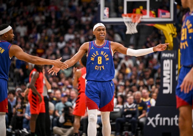 Peyton Watson of the Denver Nuggets high fives Bruce Brown (11) as he talks to Spencer Jones (21) during the fourth quarter of the Nuggets' 128-112 win over the Portland Trail Blazers at Ball Arena in Denver on Sunday, March 22, 2026. (Photo by AAron Ontiveroz/The Denver Post)
