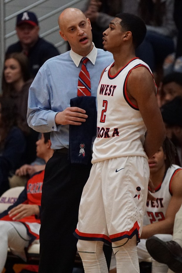 West Aurora's Camron Donatlan (2) listens as coach Brian Johnson offers insight during a break in the action during a game on Friday, Dec. 9, 2016.