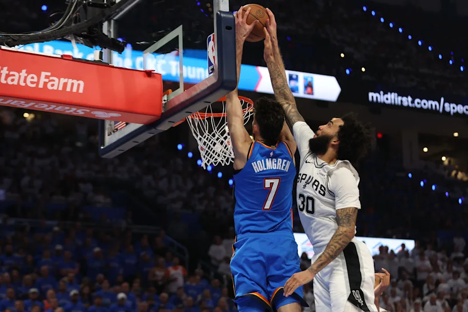 May 20, 2026; Oklahoma City, Oklahoma, USA; Oklahoma City Thunder center Chet Holmgren (7) dunks as San Antonio Spurs forward Julian Champagnie (30) defends during the third quarter during game two of the western conference finals for the 2026 NBA playoffs at Paycom Center. Mandatory Credit: Brett Rojo-Imagn Images