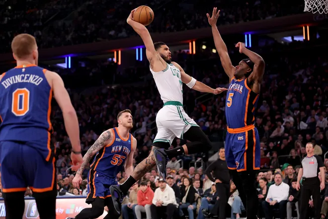 Feb 24, 2024; New York, New York, USA; Boston Celtics forward Jayson Tatum (0) drives to the basket against New York Knicks forward Precious Achiuwa (5) and center Isaiah Hartenstein (55) and guard Donte DiVincenzo (0) during the first quarter at Madison Square Garden. Mandatory Credit: Brad Penner-USA TODAY Sports