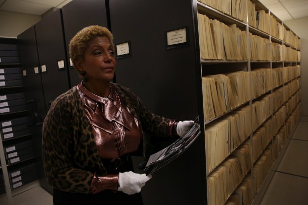 Linda Johnson Rice handles some of the photos in the archives of Johnson Publishing, owner of Ebony and Jet magazines, on Jan. 22, 2015. (Nancy Stone/Chicago Tribune)