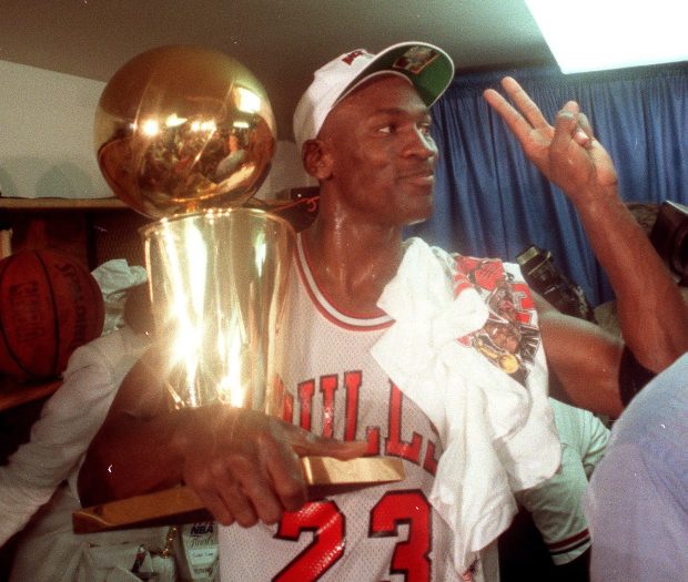 Michael Jordan holds onto the NBA Championship trophy after the Chicago Bulls won their second straight title by beating the Portland Trail Blazers on June 14, 1992, in Chicago. (Charles Cherney/Chicago Tribune)