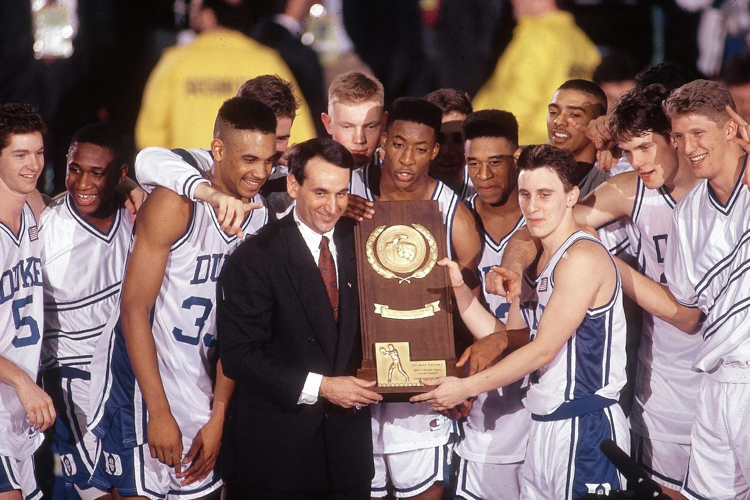 Duke coach Mike Krzyzewski and Bobby Hurley victorious with trophy after winning 1991 championship game.