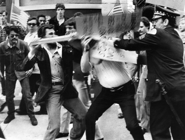 A gay rights demonstrator clubs a Chicago policeman outside the Medinah Temple on June 14, 1977, before the Anita Bryant performance in Chicago. The demonstrator was arrested, along with seven others outside the hall. (Don Casper/Chicago Tribune) 