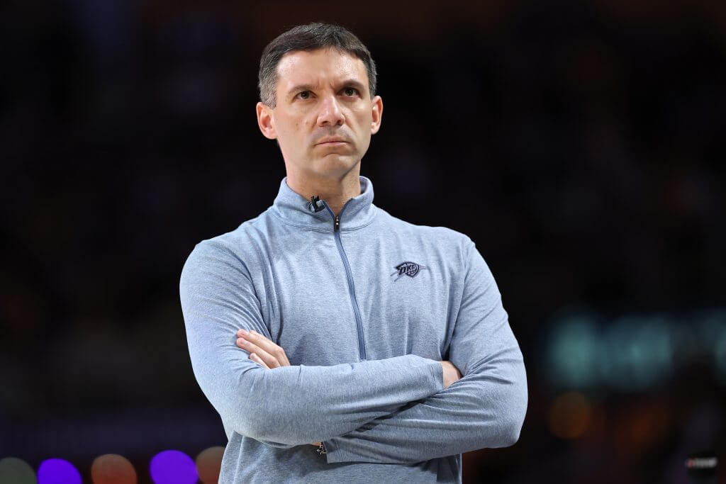 Thunder head coach Mark Daigneault observes during a game with his arms folded.