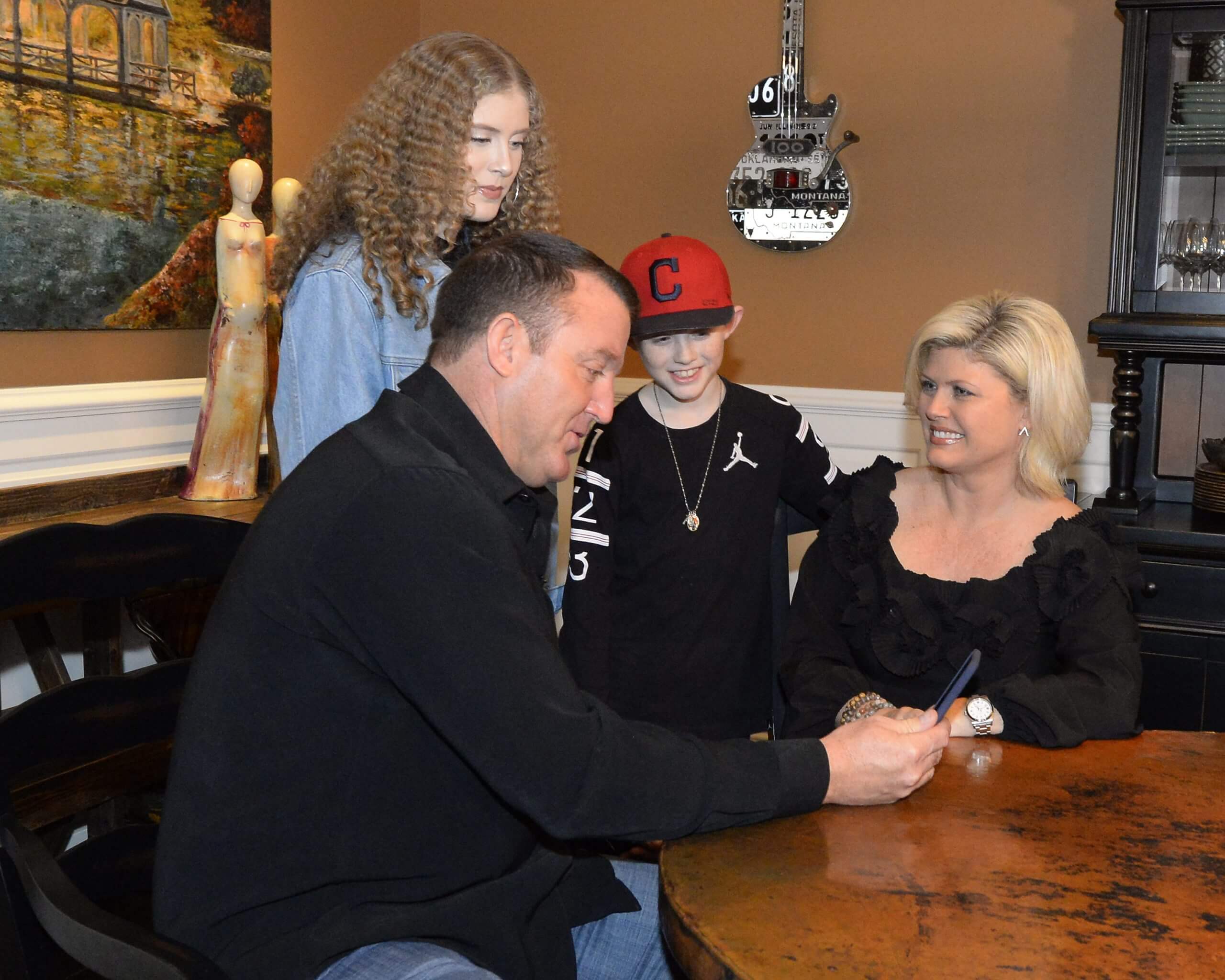 Jim Thome, holding a phone, is shown with daughter Lila, left rear, son Landon (in red ballcap with black "C") and wife Andrea.