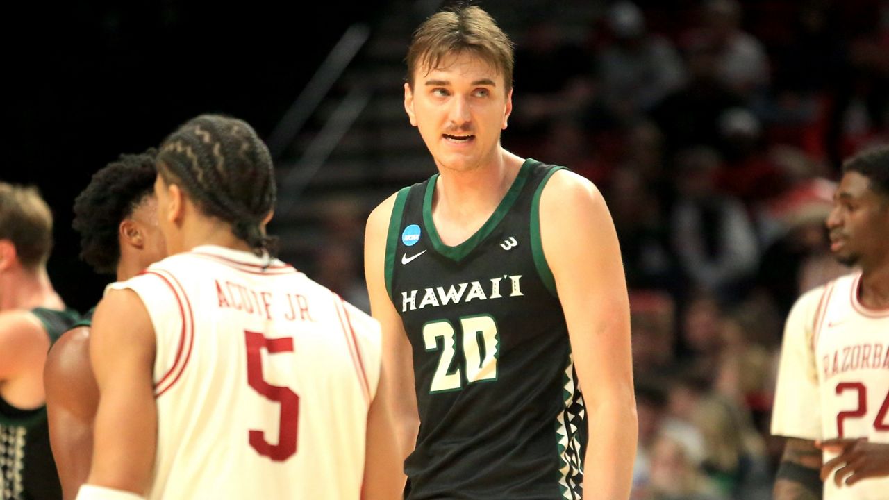 Hawaii center Isaac Johnson stood next to Arkansas guard and future NBA first-round draft pick Darius Acuff Jr. in the teams' NCAA Tournament game at the Moda Center in Portland, Ore., in March. Johnson produced 20 points for the Philadelphia 76ers in his first NBA Summer League game in Las Vegas on Thursday.