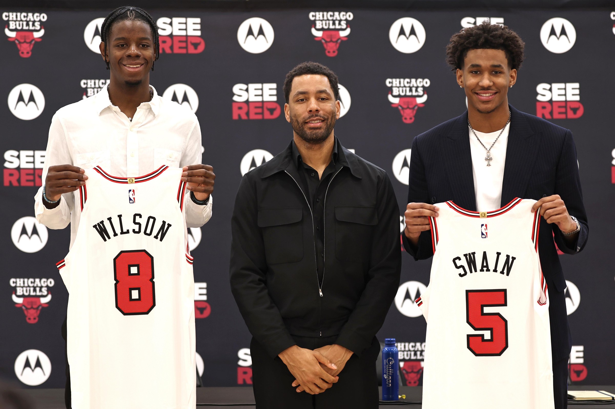 CHICAGO, ILLINOIS - JUNE 26: Chicago Bulls first round draft picks Caleb Wilson (left) and Dailyn Swain (right) pose for a portrait with Chicago Bulls Executive Vice President of Operations Bryson Graham (center) during a press conference at Advocate Center on June 26, 2026 in Chicago, Illinois. (NOTE TO USER: User expressly acknowledges and agrees that, by downloading and or using this photograph, User is consenting to the terms and conditions of the Getty Images License Agreement. (Photo by Geoff Stellfox/Getty Images)