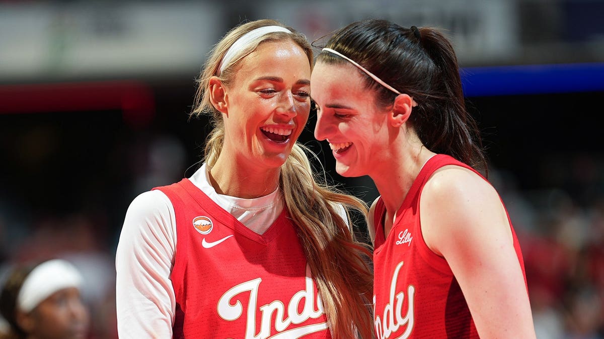 Sophie Cunningham and Caitlin Clark smile during a game at Gainbridge Fieldhouse.