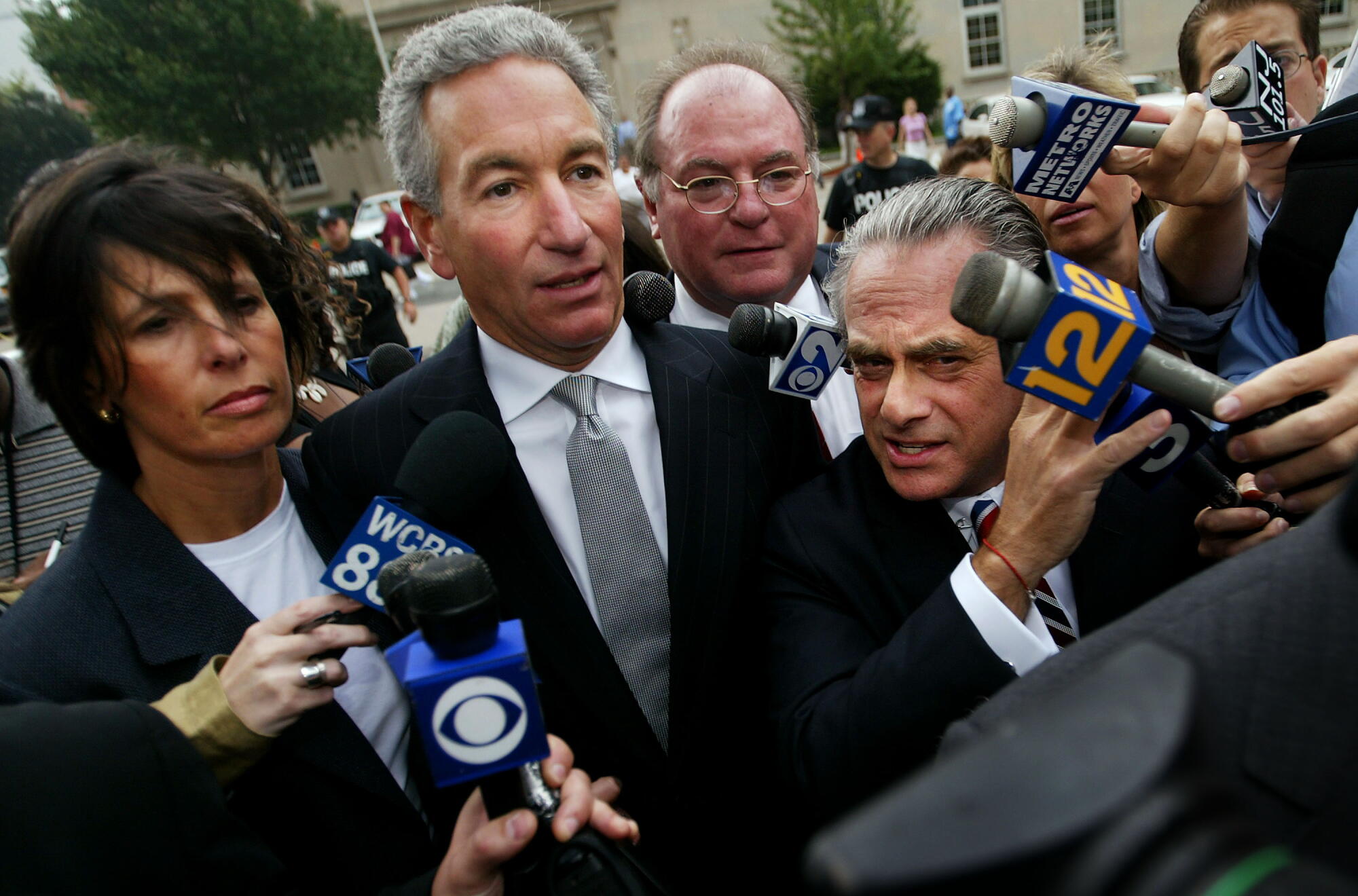 Charles Kushner, center, wading though the media