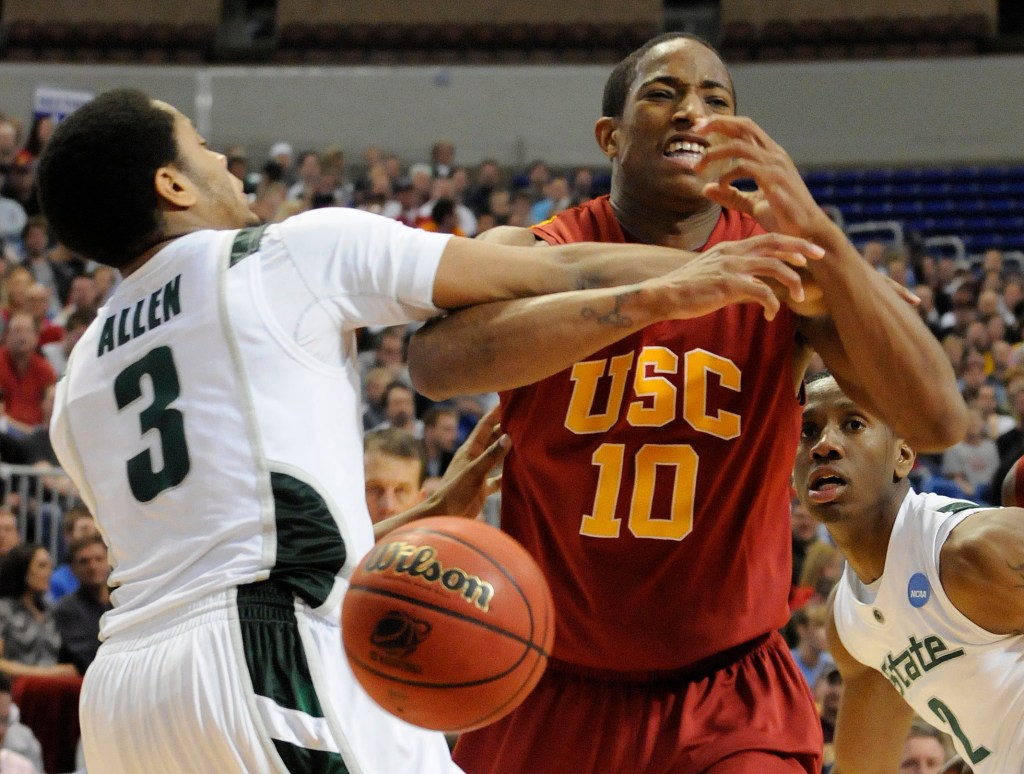 DeMar DeRozan of USC and Chris Allen of Michigan State battling for the ball during a basketball game.
