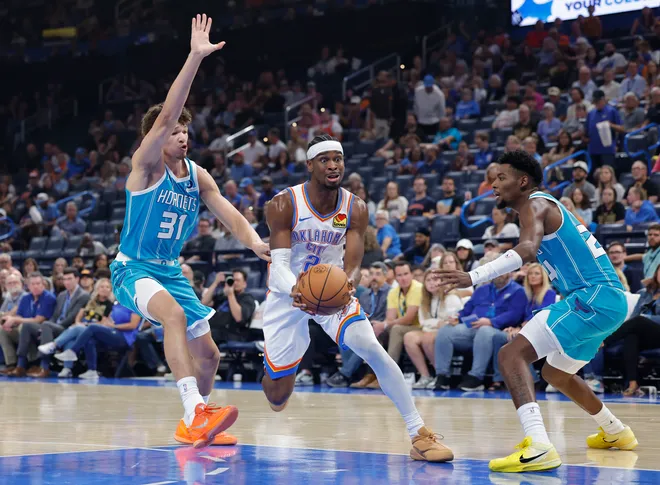 Oct 9, 2025; Oklahoma City, Oklahoma, USA; Oklahoma City Thunder guard Shai Gilgeous-Alexander (2) drives to the basket between Charlotte Hornets forward Tidjane Salaün (31) and forward Brandon Miller (24) during the second quarter of a game between the Charlotte Hornets and the Oklahoma City Thunder at Paycom Center. Mandatory Credit: Alonzo Adams-Imagn Images