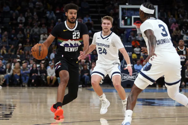 Nov 24, 2025; Memphis, Tennessee, USA; Denver Nuggets forward Cameron Johnson (23) dribbles as Memphis Grizzlies guard Cam Spencer (24) and forward Kentavious Caldwell-Pope (3) defends during the second quarter at FedExForum. Mandatory Credit: Petre Thomas-Imagn Images