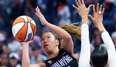 A female basketball player wearing a black "Valkyries" jersey with the number 2 prepares to shoot while a defender in a white jersey with the number 7 raises her hands.