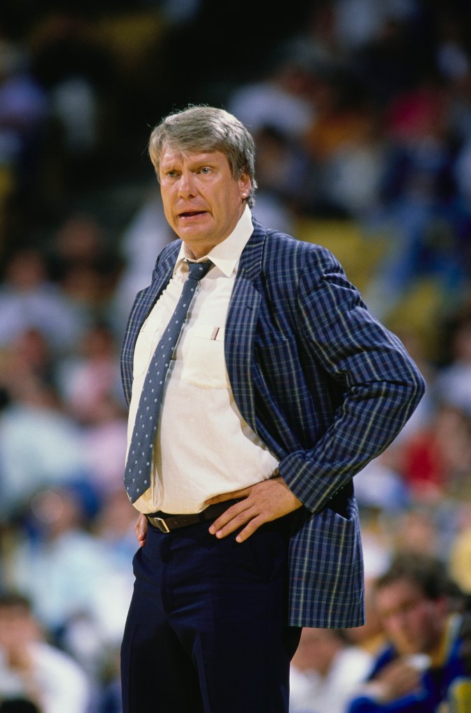 Basketball coach Bobby Knight in a plaid jacket, shirt, and tie, with hands on his hips.