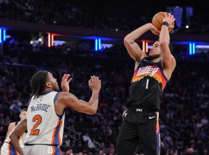 Jan 17, 2026; New York, New York, USA; Phoenix Suns guard Devin Booker (1) shoots the ball while defended by New York Knicks guard Miles McBride (2) during the second half at Madison Square Garden. Mandatory Credit: John Jones-Imagn Images