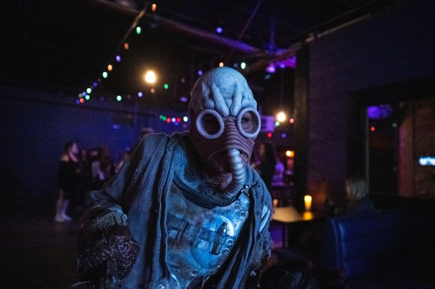 An actor scares people in a bar at The 13th Floor haunted house in Denver on Saturday, Sept. 19, 2026