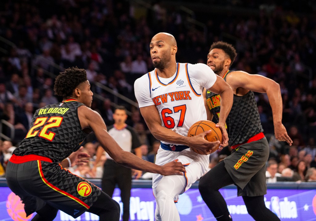 Taj Gibson of the New York Knicks driving to the basket as Cam Reddish of the Atlanta Hawks defends.