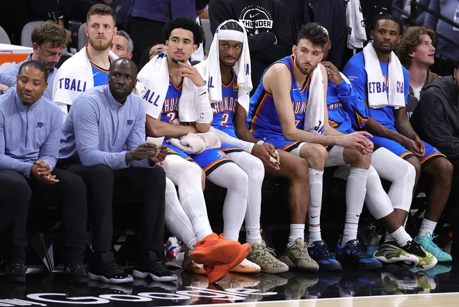 SAN ANTONIO, TEXAS - MAY 24: Jared McCain #3, Shai Gilgeous-Alexander #2 and Chet Holmgren #7 of the Oklahoma City Thunder look on from the bench during the fourth quarter after scoring a goal in Game Four of the NBA Western Conference Finals at Frost Bank Center on May 24, 2026 in San Antonio, Texas.