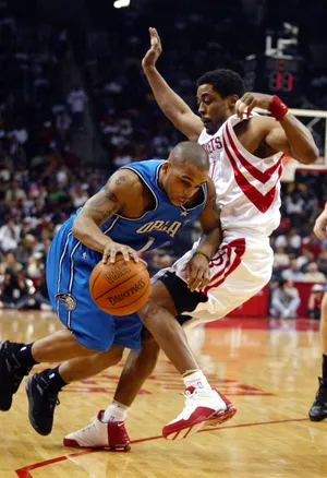 Orlando Magic guard Doug Christie (L) drives to the basket past Houston Rockets guard Rod Strickland during the first half of play January 24, 2005 in Houston. REUTERS/Richard Carson  RJC