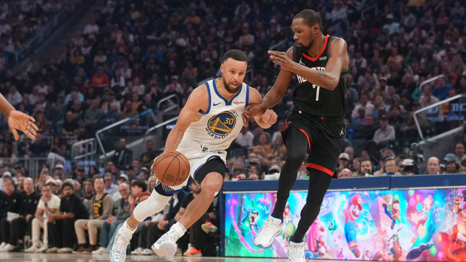 Golden State Warriors guard Stephen Curry (30) dribbles the ball next to Houston Rockets forward Kevin Durant (7) in the first quarter at the Chase Center.