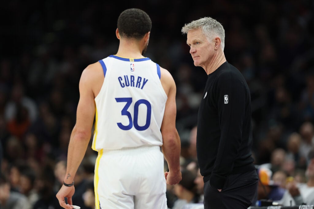 Head coach Steve Kerr (R) of the Golden State Warriors talks with Stephen Curry #30 during the second half of the NBA game