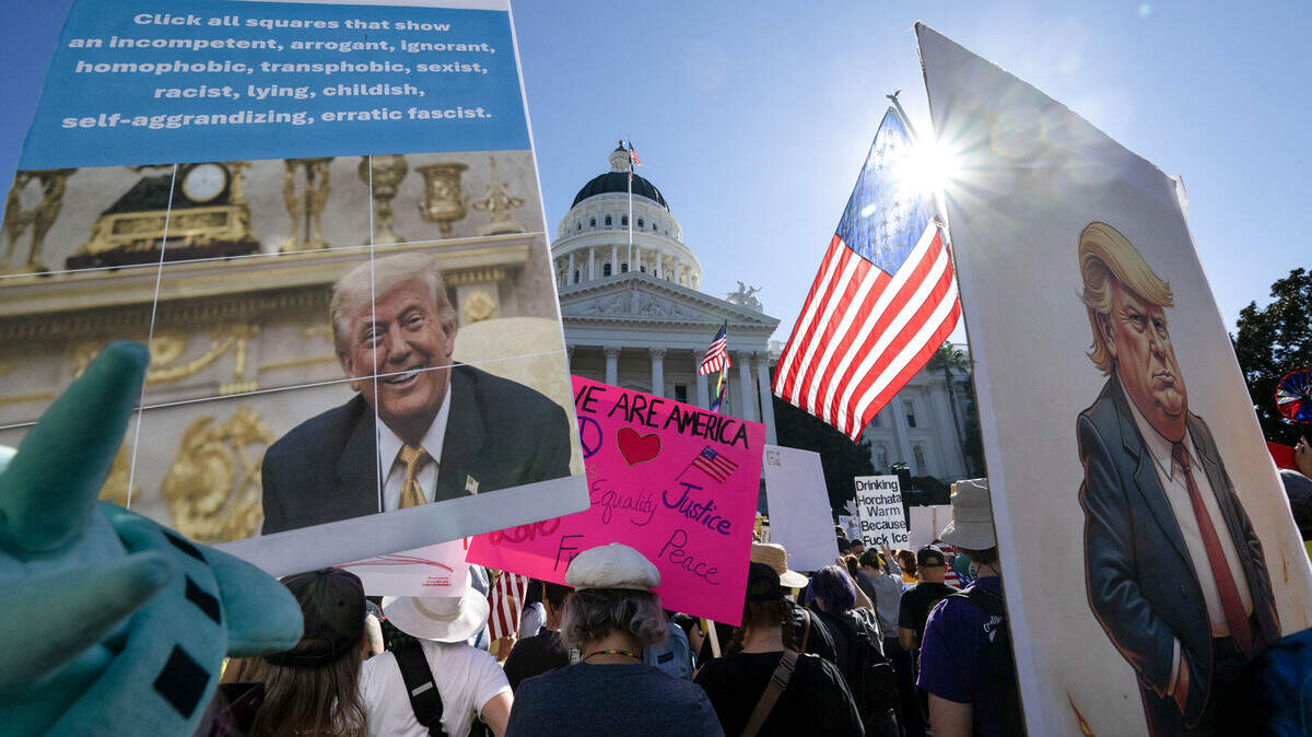Demonstrators hold signs during the Demonstrators hold signs during the "No Kings" protest at the state Capitol in Sacramento on Saturday, Oct. 18, 2025.