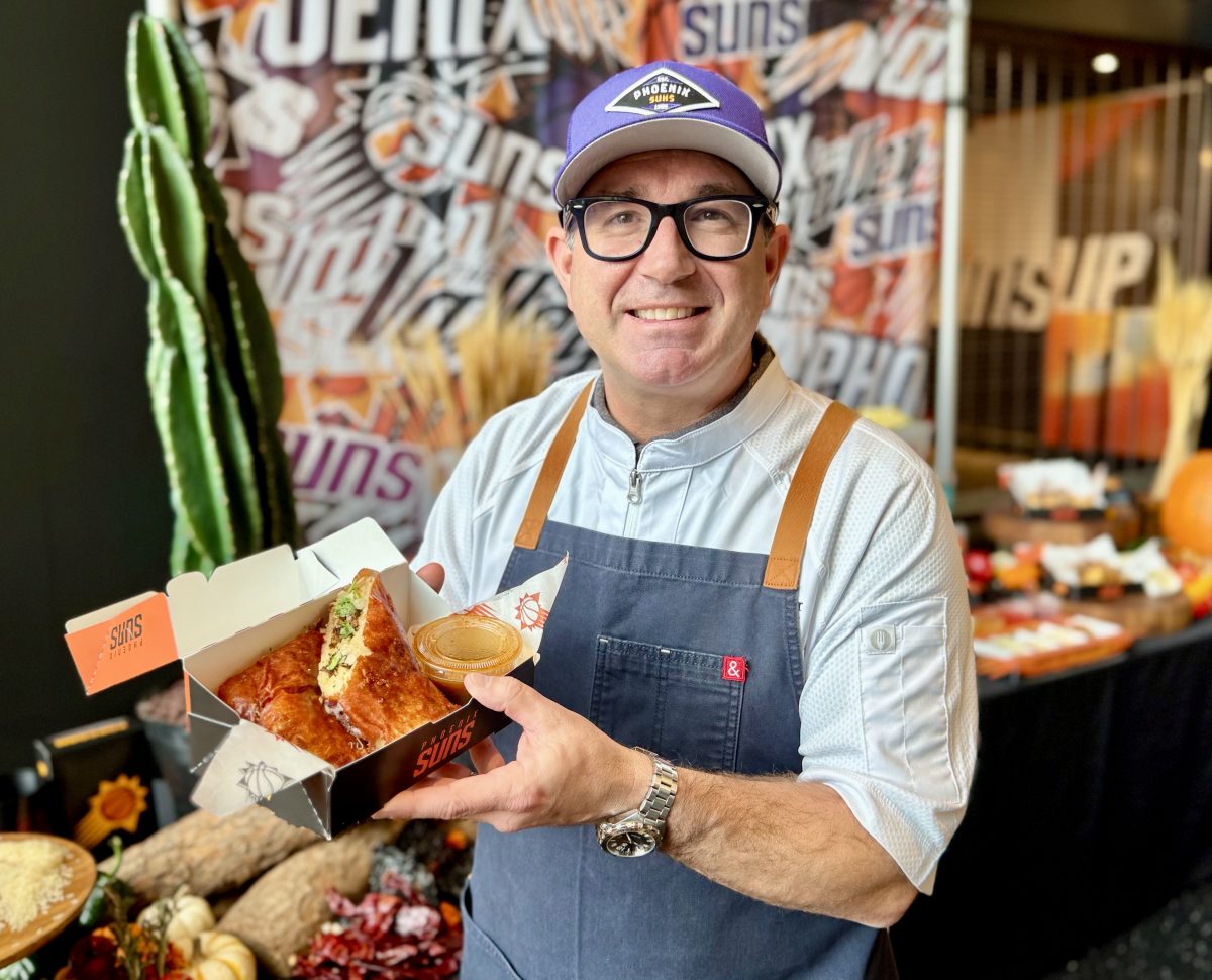 Chef Otis Huemmer holds a Birria Crunch Burro inside Mortgage Matchup Center.