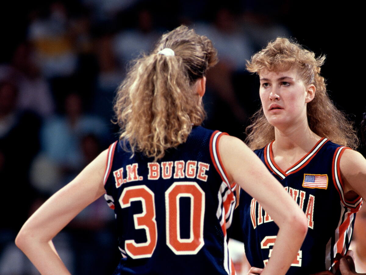 Heidi Burge looking at her twin sister Heather Burge on a basketball court