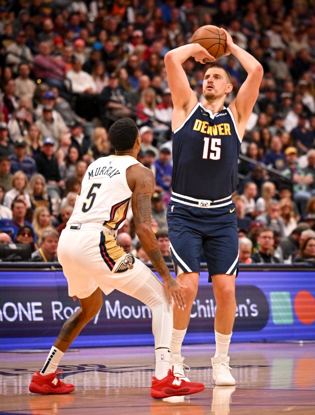 Nikola Jokic (15) of the Denver Nuggets shoots over Dejounte Murray (5) of the New Orleans Pelicans during the first quarter at Ball Arena in Denver, Colorado on Saturday, October 24, 2026. (Photo by AAron Ontiveroz/The Denver Post)