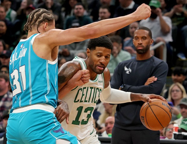 Boston Celtics forward Paul George tries to get around Charlotte Hornets forward Tidjane Salaun, left, during the first half. Matt Stone/Boston Herald