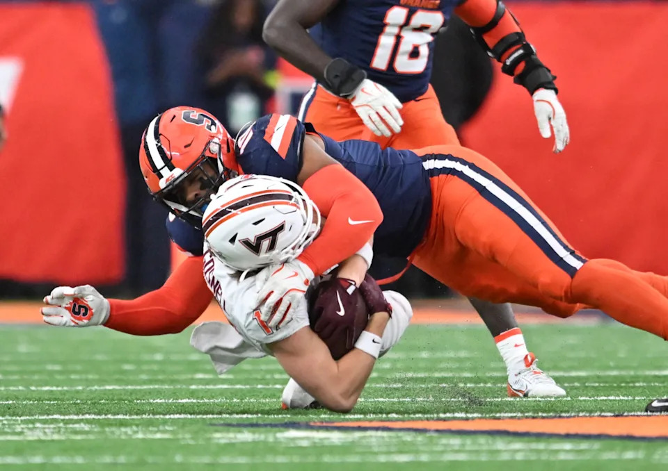 Nov 2, 2024; Syracuse, New York, USA; Syracuse Orange defensive lineman Fadil Diggs (10) makes a tackle on Virginia Tech Hokies wide receiver Stephen Gosnell (12) in the first quarter at JMA Wireless Dome. Mandatory Credit: Mark Konezny-Imagn Images Mark Konezny-Imagn Images