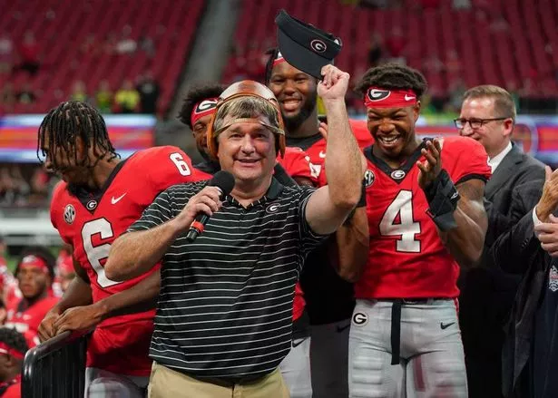 Kenny McIntosh #6 and Nolan Smith #4 react as head coach Kirby Smart of the Georgia Bulldogs wears the Old Leather Helmet after winning the Chick-fil-A Kickoff Game between Oregon and Georgia on September 03, 2022 in Atlanta, Georgia